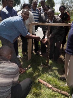 Local community members building a hand washing facility called a "tippy tap", located outside pit toilets. CHV's are trained to build facilities like these using local materials as part of their training and certification as "Community Health Volunteers".