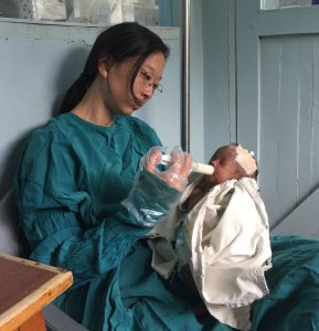 OB Catherine feeds an orphaned baby in nursery.